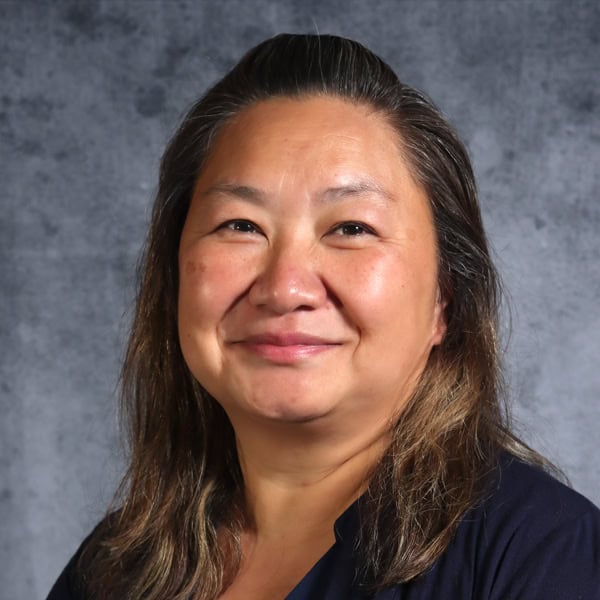 Smiling woman with long hair in formal attire.