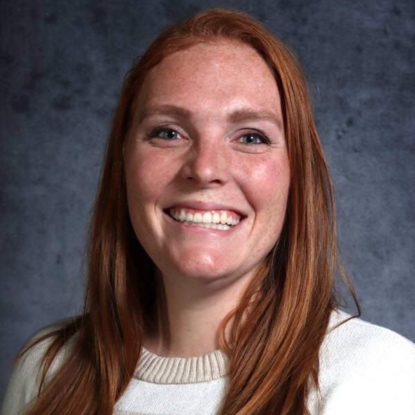 Smiling woman with red hair and sweater